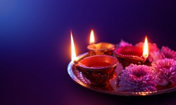 Happy Diwali - Colorful clay diya lamps lit during diwali celebration with copy space