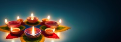 Happy Diwali, Diya oil lamps lit on colorful rangoli with copy space