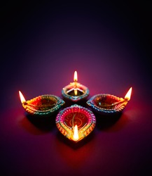 Colorful clay diya lamps lit during diwali celebration