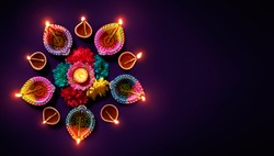 Colorful clay diya lamps with flowers on purple background