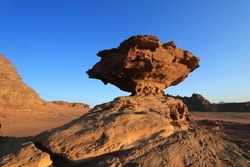 Wadi Rum desert has a couple of famous, solitary, unusual rock formations. Mushroom rock is one of them. Like all other sandstone rock formations, this photogenic rock was shaped naturally by erosion 