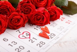 Calendar page with the red hearts  and  bouquet of red roses on February 14 of Saint Valentines day.