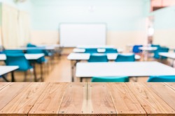 Look out from the table, blur image of empty classroom as background.