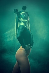 Portrait of beautiful cyber model woman posing wearing futuristic glasses on head with neon light in a virtual tech environment