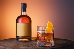 Bottle and glass with blended malt scotch whisky over blue orange gradient background