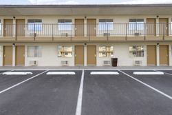 two story motel with parking lot in foreground