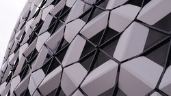 Modern architecture. Panels like honeycombs, unusual panels. Geometric shape. Part of a modern building. The building is assembled from geometric panels of hexagonal shapes - a hexagon. On a white bac