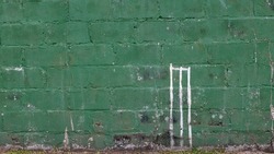 wicket stumps painted on a brick wall