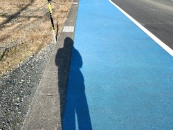 human shadow on the side of the road. sunny day