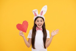 oh my god. time for fun. love. adorable kid holding red heart. paschal spring holiday. happy teen girl wear bunny ears. happy easter. childhood happiness. child in rabbit ears and bow tie.