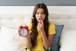 Worried about being late. Anxious girl hold alarm clock. Time late. Oversleeping morning