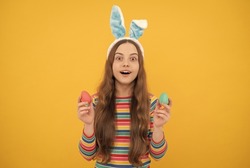 amazed easter teen girl in rabbit bunny ears holding painted eggs for holiday egg hunt, bunny hunt