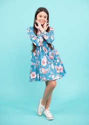 Full length of teenager child wearing summer dress. Happy teenager, positive and smiling emotions. Elegant teenager child girl in fashion dress. Girl in cotton dress isolated on blue background.