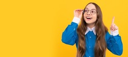 Clever idea. Clever girl in eyeglasses yellow background. School age child with raised finger. Eureka. Child face, horizontal poster, teenager girl isolated portrait, banner with copy space.