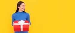 Woman isolated face portrait, banner with copy space. seasonal sales. smiling girl with box on yellow background. boxing day. present and gifts buy.
