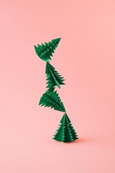 Christmas composition with green paper trees on powder pink background. Happy winter holidays. New year minimal concept.