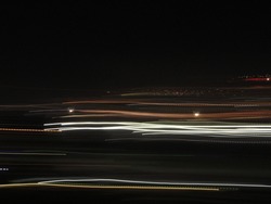 Several Lines of different colors and sizes moving in the dark. Camera movement