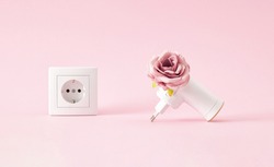 Creative concept of  air, room freshenerwhich instead of plugins refill have fresh flowers. A relaxing smell coming from the power outlet on pastel pink background.