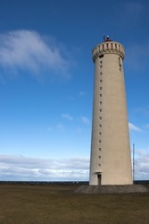 Gardskagaviti - icelandic tallest lighthouse and museum. Located on a meadow close to the old lighthouse. Blue sky with white clouds. Sudurnesjabear., Iceland