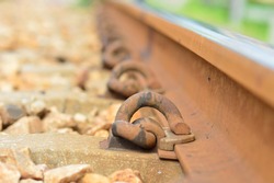 Steel retaining rails for tractors that are bent, reddish-brown color, because they are filled with iron rust. that was held on steel and railroad sleepers
