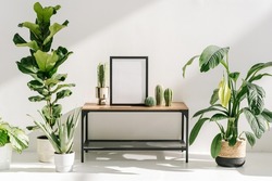 Concept of growth houseplants, greenery, wooden furniture and home decor in minimalist modern house. Picture frame with blank space or mockup art at wooden table, near plants and cactus in flower pots
