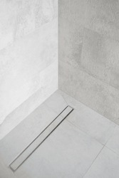 linear shower drain on tiled floor of modern enclosure in luxury bathroom, water disposal system, detail in loft washroom interior, minimalistic style