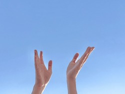 hands with beautiful clear blue sky in the background symbolizes a person that reaching a peace as high as the sky