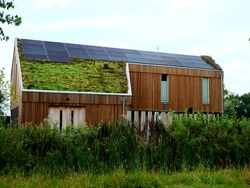 Energy neutral and carbon efficient house in the Netherlands made of wood and solar panels. The exterior is natural and wood, the roof is made of grass and is natural. The house is energy friendly.
