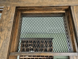 A look at a steel grate above a window to an old post office.