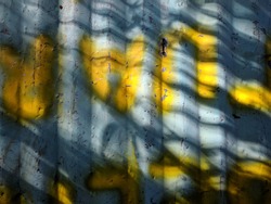 Walls made of zinc with yellow graffiti were photographed in the morning
