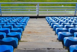 Picture of the spectator seats in the blue stadium stands lined up neatly, the photo was taken from the top position of the stadium bench