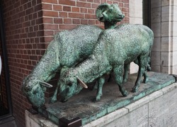 Hamburg / Germany - 07.07.2019: street scene - Street bronze sculpture - ram and two sheep, Hamburg,  Germany