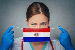 Coronavirus in Paraguay Female Doctor Portrait hold protect Face surgical medical mask with Paraguay National Flag. Illness, Virus Covid-19 in Paraguay, concept photo