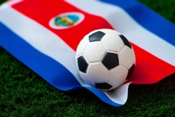Costa Rica national football team. National Flag on green grass and soccer ball. Football wallpaper for Championship and Tournament in 2022. World international match.