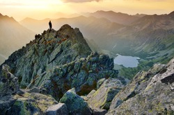 Man on the top of the hill watching wonderful scenery in mountains during summer colorful sunset in High Tatras in Slovakia