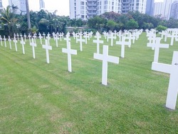 Line of holy crosses in Christian military graveyard in middle of city