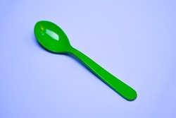 Green plastic spoon on a white background.