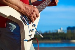 Playing guitar on the street. Street guitarist. The guitarist's hands. Electric guitar. Strings.