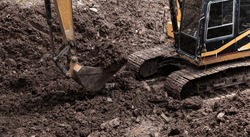 The excavator performs excavation work on the construction site. Crawler excavator digs in shale layer, excavator. Earth-moving equipment, Excavator work 
