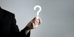 businessman holding question mark. concept of Question mark and FAQs, Ask quiestion online, FAQ concept, what how and why, search information on internet. 