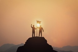 Business Success, Leadership and Success and Goal Concepts. Silhouette of businessman with flags on mountain peaks above sky and sunset background.