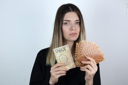 Young woman with casual clothes holding tarot book and tarot cards. White isolated background.