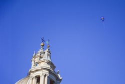 Cat shaped air balloon flying in the blue sky in front of Sant'Agnese church in Piazza Navona, Rome, Italy