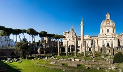 Wide angle view of the blue sky above the ancient ruins, Church of the Most Holy Name of Mary at the Trajan Forum and Trajan column in the morning light in Rome, Italy