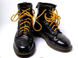 black boots with yellow laces. black leather boots isolated on white