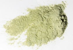 A pile of loose light green powder pigmant for organic cosmetic or food ingredient on white background. Texture. Close-up. Top view