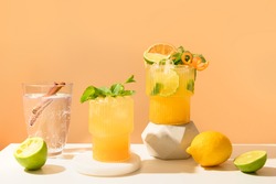 Classic cocktails, lemonade, mai tai, mojito with lime on modern still life with podium on a beige background. for Summer freshness beverage.