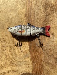 Mechanical Fishing lure in a wooden table . This bait is used for jigging and casting in ocean, sea , river , or a lake.