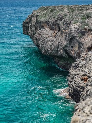 The photo shows the Atlantic Ocean with a rocky coast. The exotic island's beach contains many rocks and grottoes. The rocky landscape and the sea are a great vacation spot.