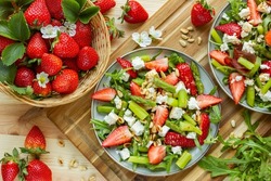 healthy food, fresh strawberries in the basket, summer, spring salad seasonal, green asparagus, rocket, fresh and healthy, herbs, homemade salad, ingredients, wooden cutting board, flatlay, appetizer